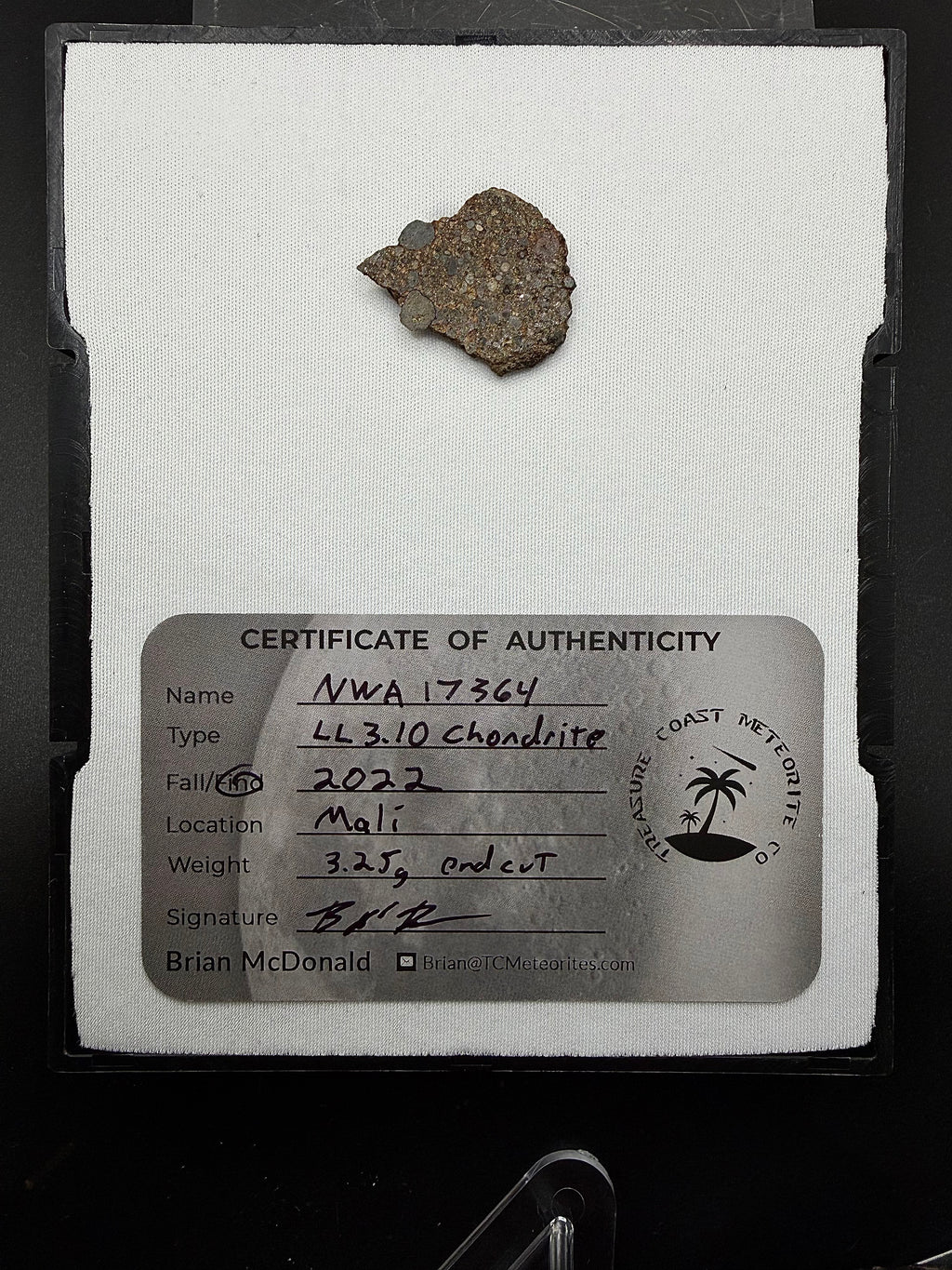 Display photo of NWA 17364 LL3.10 ordinary chondrite end cut with certificate of authenticity showing sharply defined spherical chondrules, 3.25g