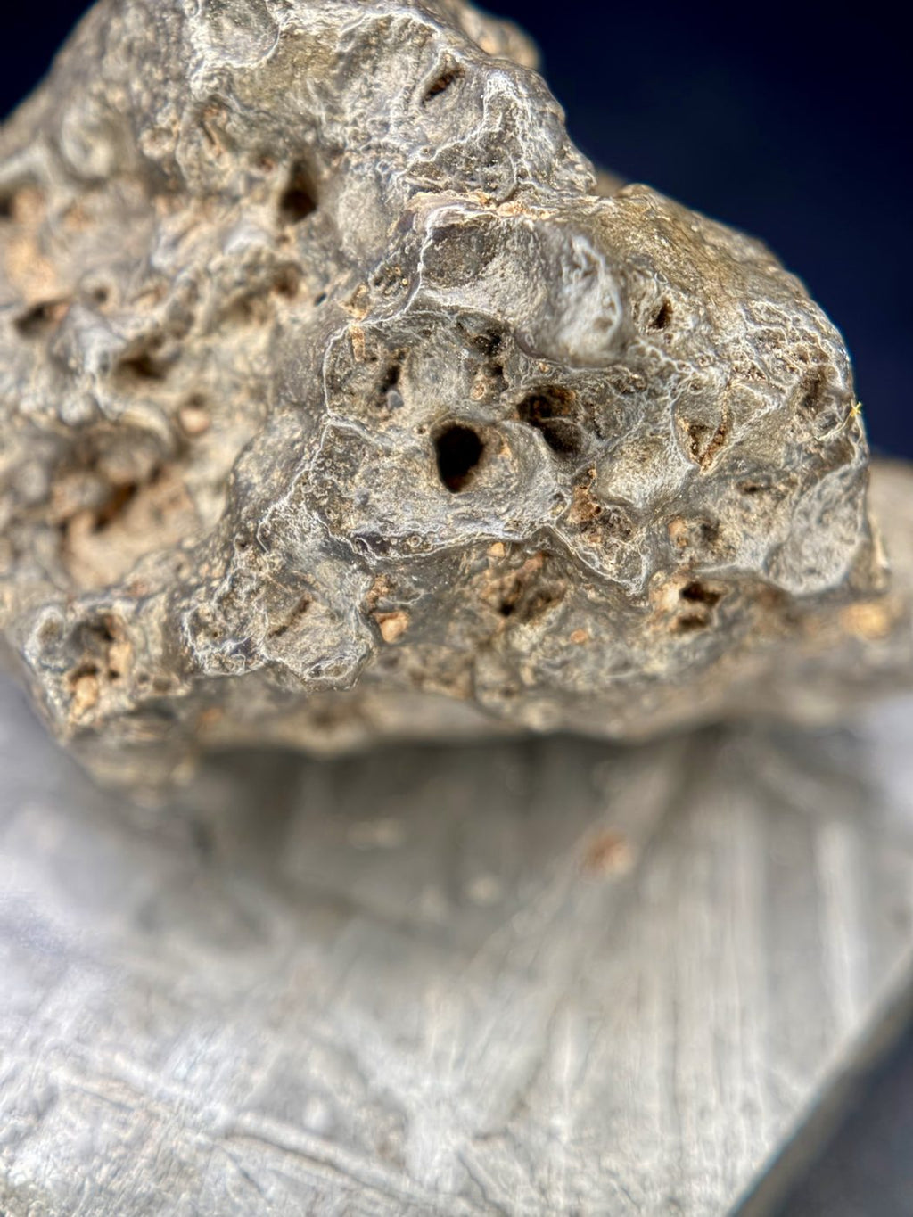 Deep pits and tan material in the hollows of the NWA 17706 lunar meteorite surface