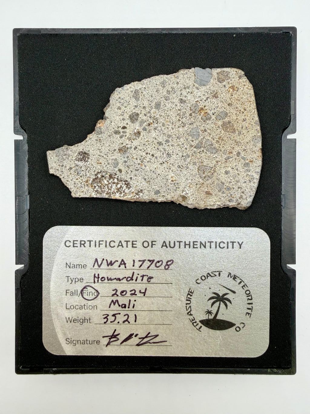 Full view of NWA 17708 howardite meteorite slice showing brecciated face alongside Treasure Coast Meteorite Co. certificate of authenticity card - 35.21g
