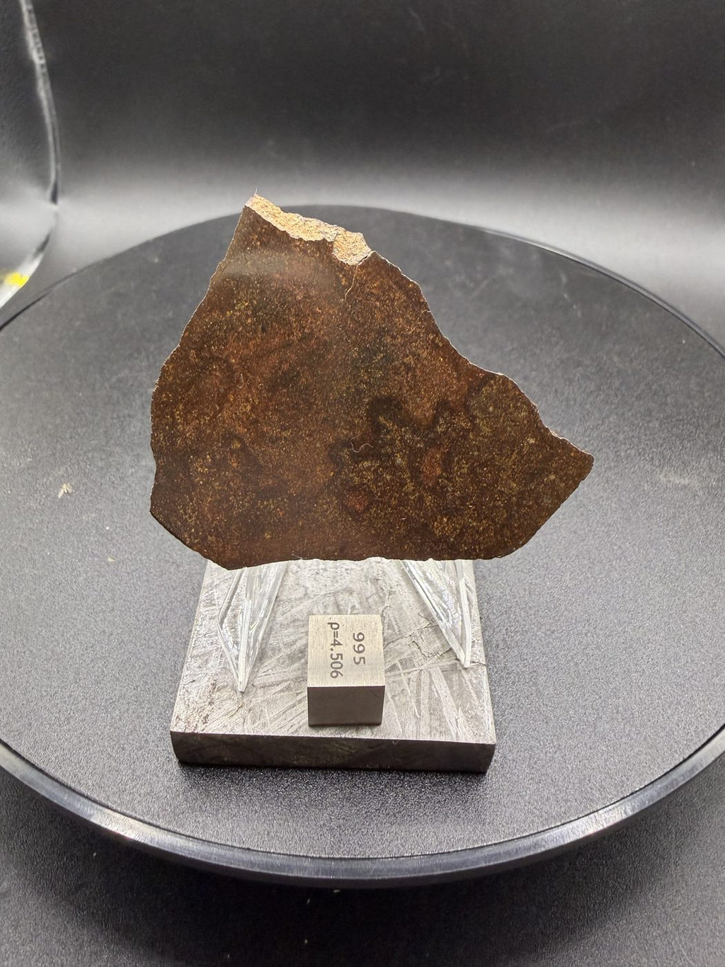 NWA 17916 CO3 carbonaceous chondrite meteorite slice displayed upright with reference cube for scale, 12.00g