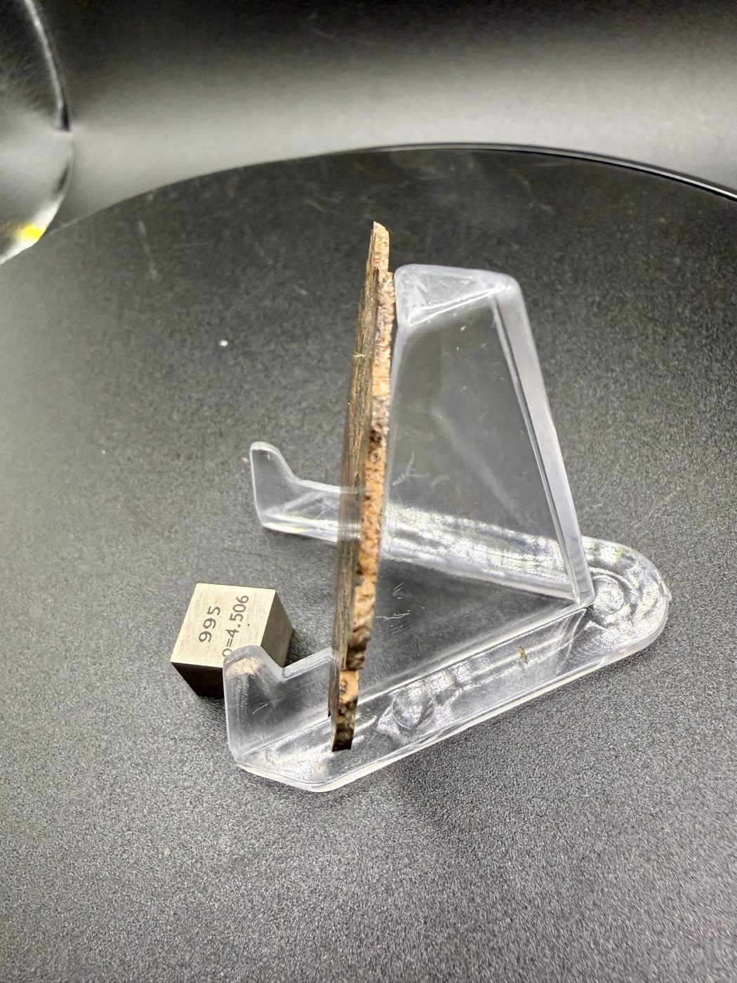 NWA 18591 diogenite meteorite, 6.57g full slice edge profile showing thickness beside a 1cm scale cube