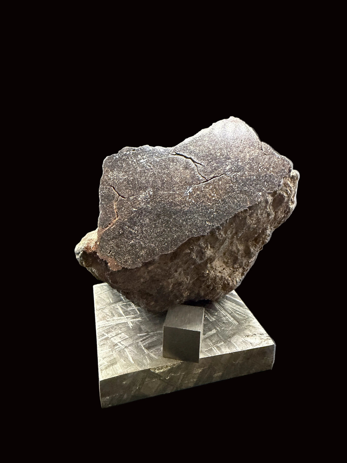 NWA 18593 winonaite meteorite end cut, 279.74 g, viewed at an angle to show the polished face and weathered exterior