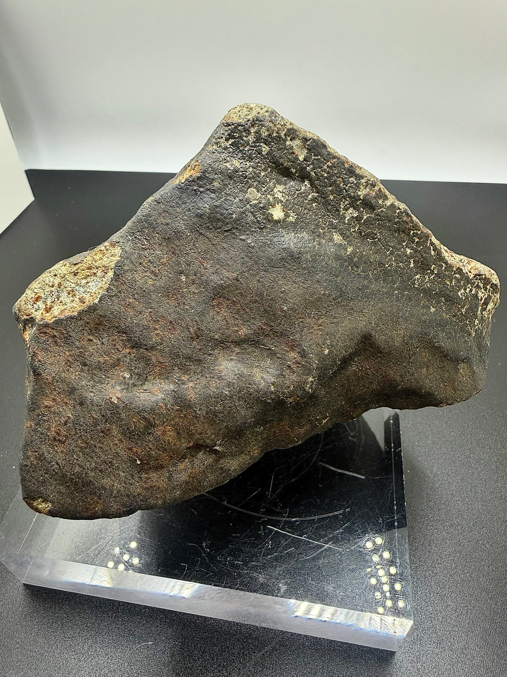Base view of NWA XXX unclassified ordinary chondrite meteorite showing fusion crust and orientation features, 1091.71g