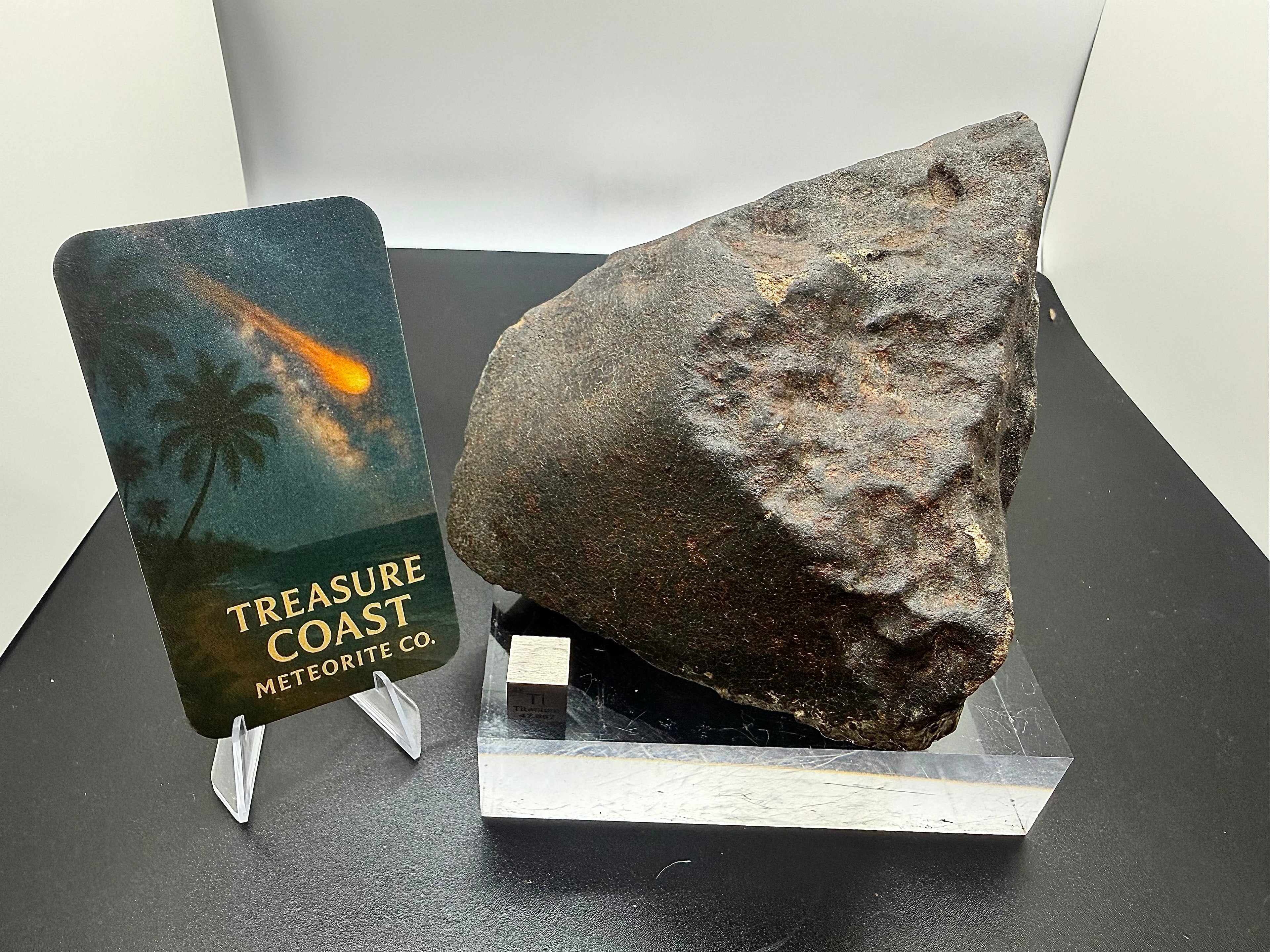 Branded display of NWA XXX unclassified ordinary chondrite meteorite oriented individual with Treasure Coast card, 1091.71g