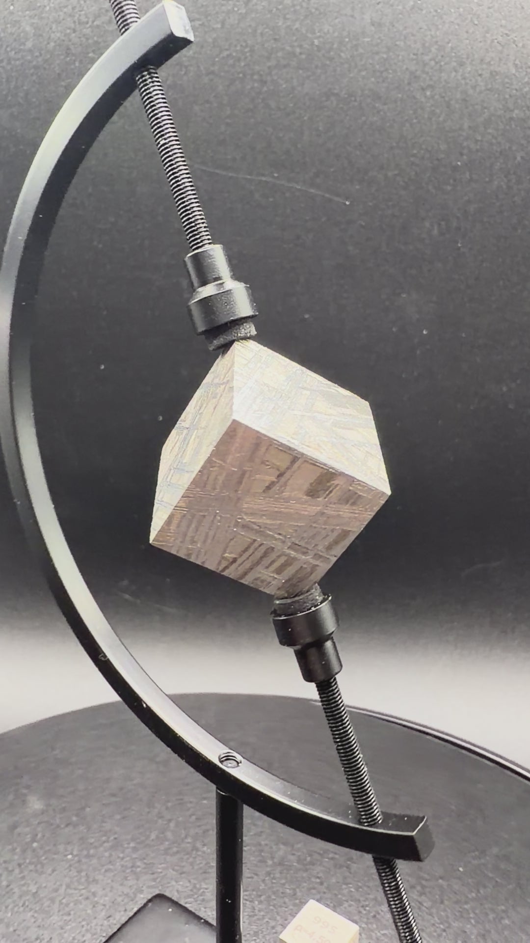 Video of Muonionalusta IVA iron meteorite cube turning on display stand showing etched faces, 65g