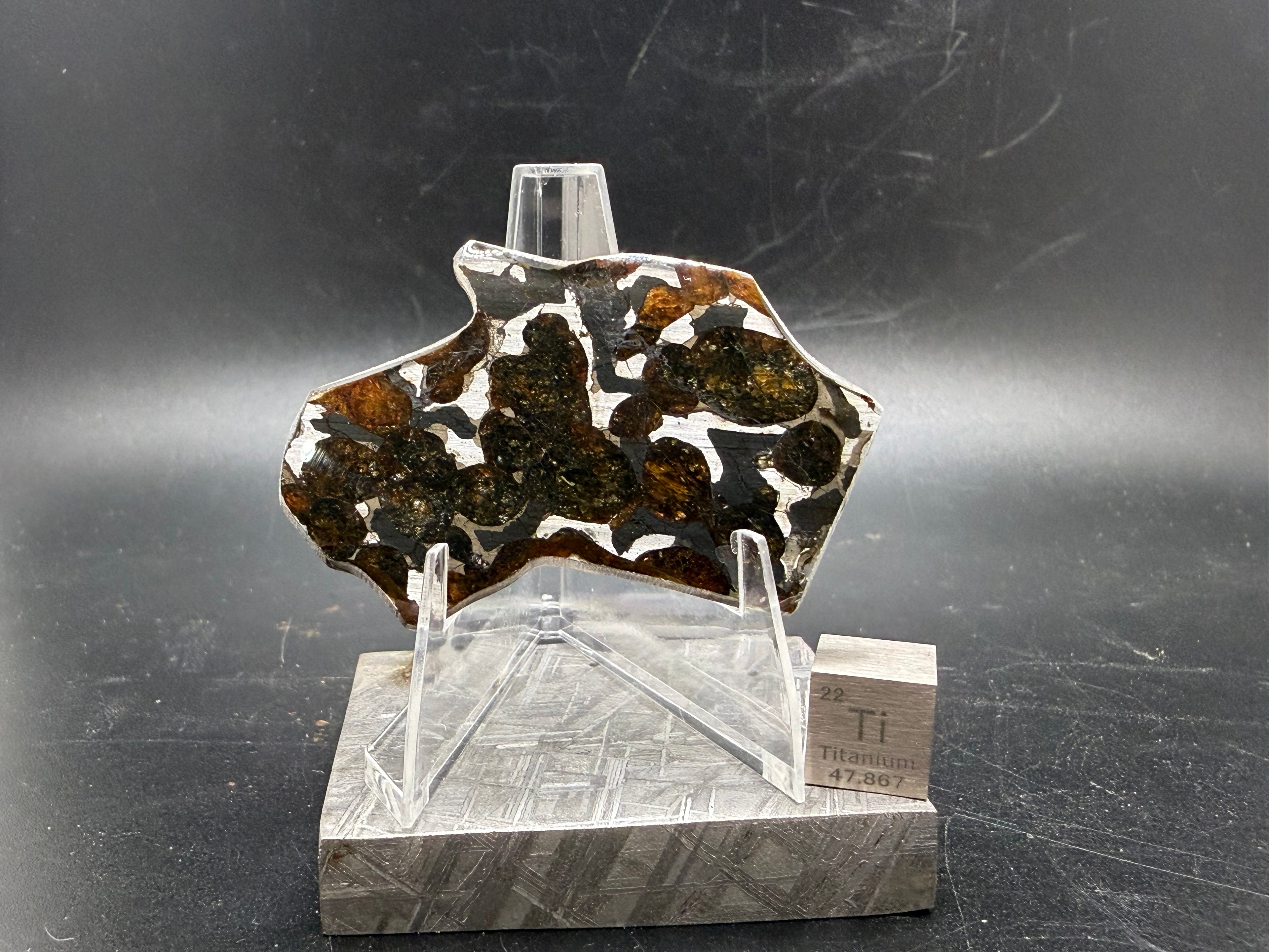 Sericho pallasite meteorite slice 9.33g on acrylic stand, olivine crystals in iron-nickel matrix, stony-iron meteorite, Treasure Coast Meteorite Co.