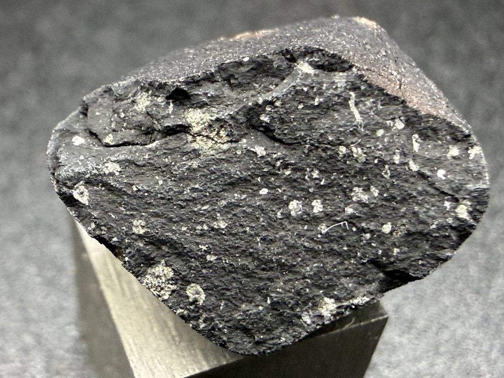 Tarda C2-ungrouped carbonaceous chondrite, 2.03g individual with fresh black fusion crust, on a 1cm scale cube, Morocco