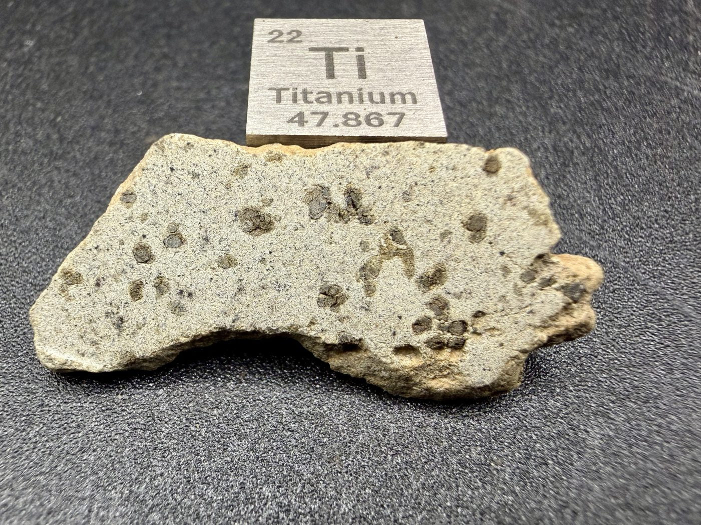 Tarkint 001 olivine-phyric shergottite full slice, 1.27 g, cut face beside titanium element cube
